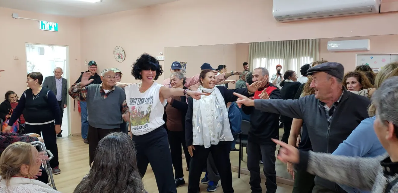 Group of people dancing and enjoying together indoors.
